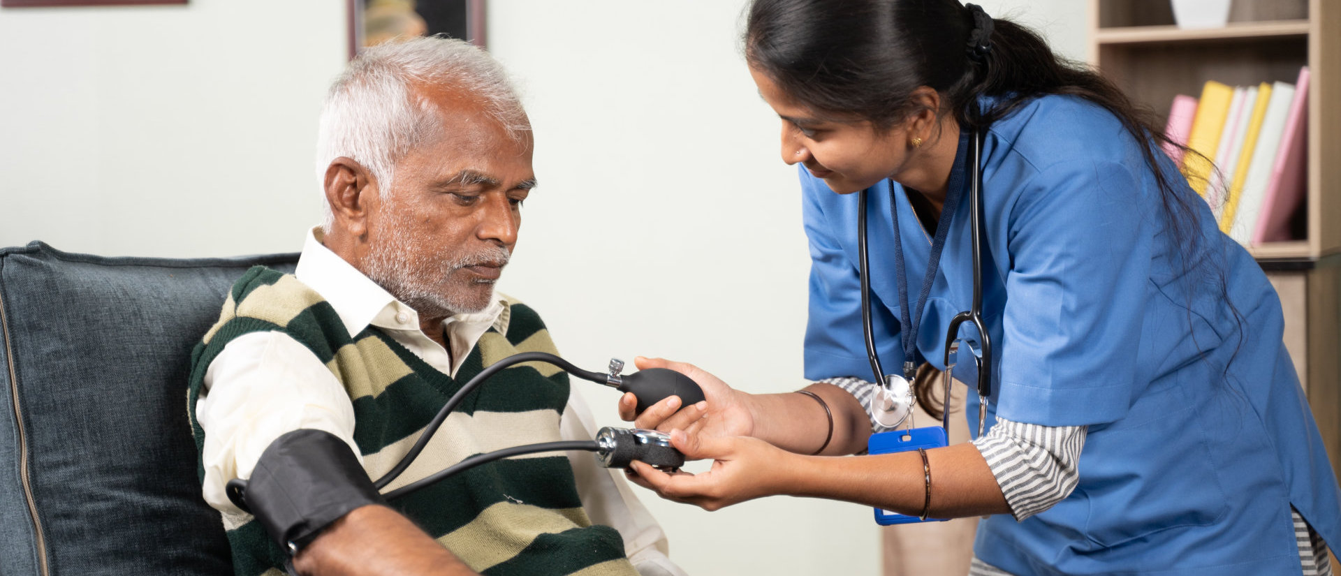 image of a female caregiver taking care of an elderly man